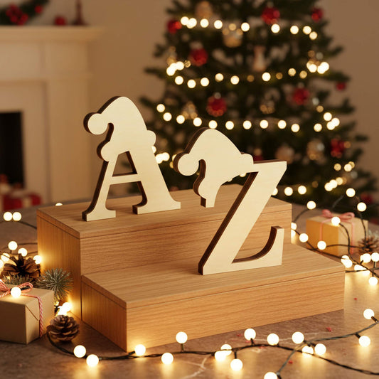 Personalized laser cut wooden letters featuring festive Santa hat details from the Alphabet in the Hat collection, displayed as tabletop initials with a glowing Christmas tree in the background.