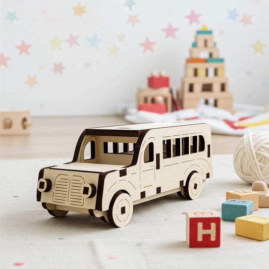 Laser cut wooden plywood toy bus with dark brown accents, featuring detailed window cutouts and engraved wheels. The 3D puzzle-style bus sits on a light rug in a nursery with wooden building blocks and star wall decals in the blurred background