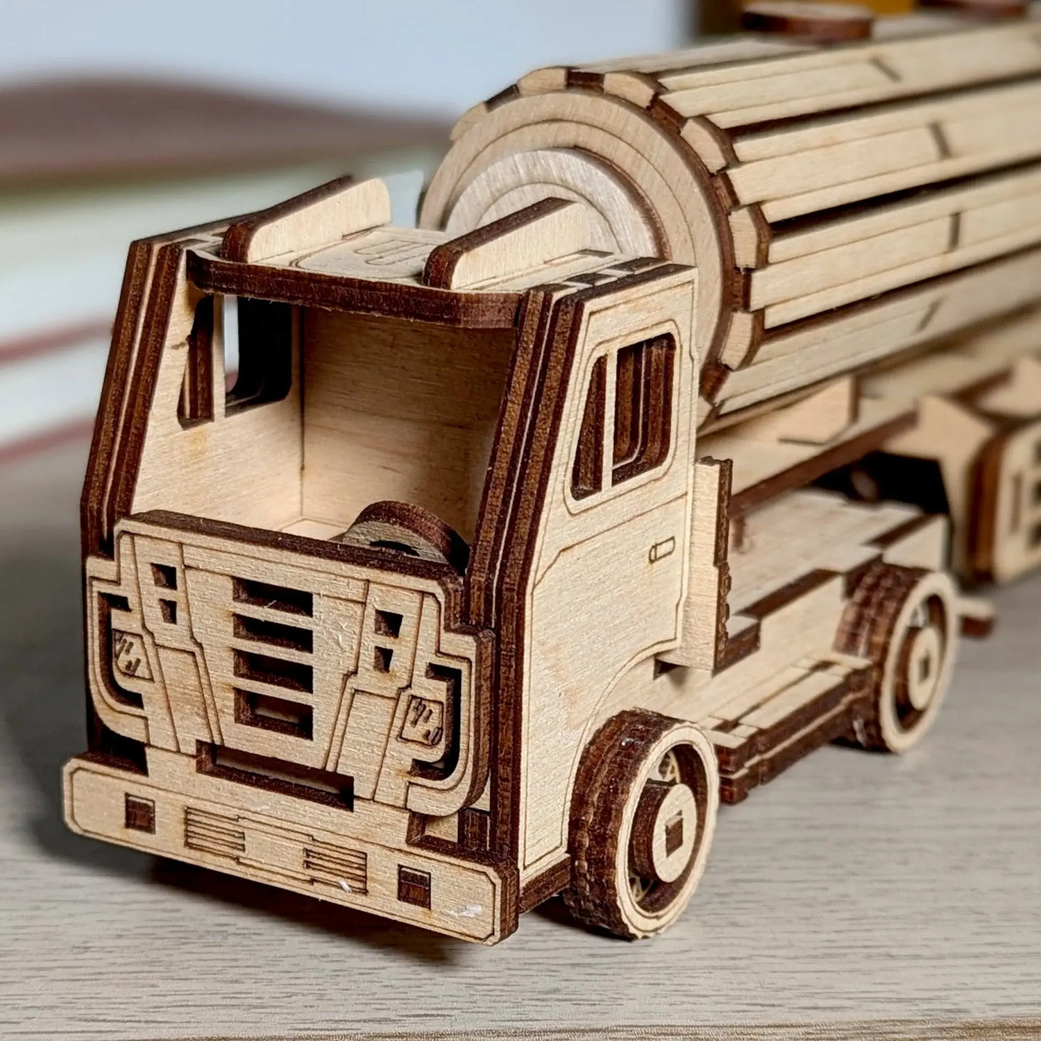 Miniature assembly tank truck puzzle made of laser cut plywood, showcasing realistic wheels and dark burned edge details