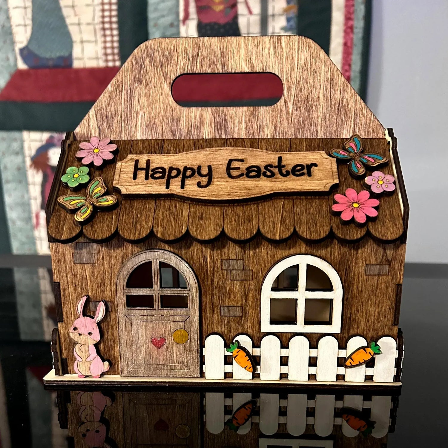 Happy Easter basket box made of laser cut plywood, featuring painted details of a bunny, fence, carrots, and butterflies.