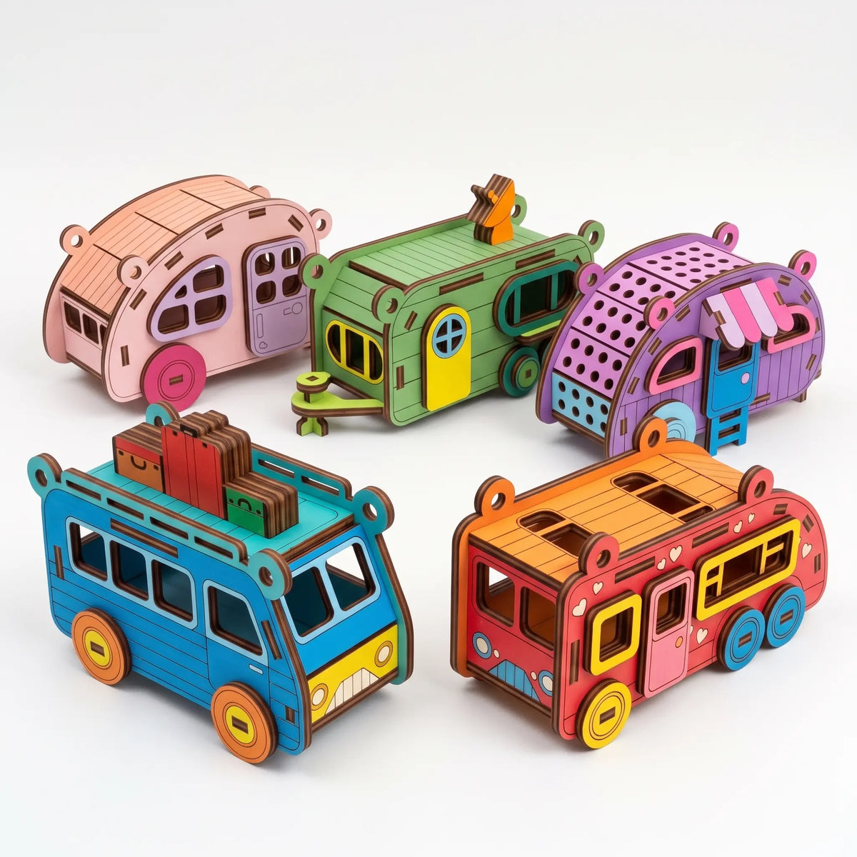Set of five colorful painted laser cut plywood camper ornaments and travel trailers arranged on plain white background.