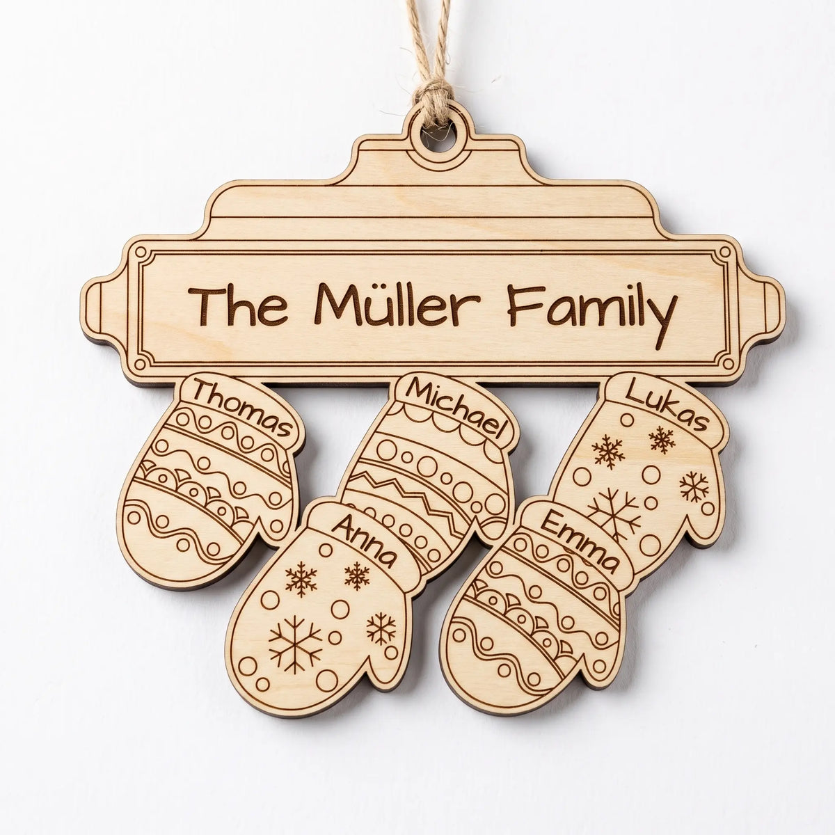 Natural laser cut plywood family mitten ornament with five personalized names hanging on twine over plain white background.