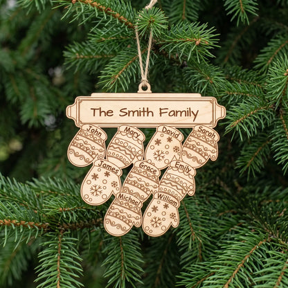 Natural laser cut plywood family mitten Christmas ornament with nine engraved names hanging by twine on green pine tree.