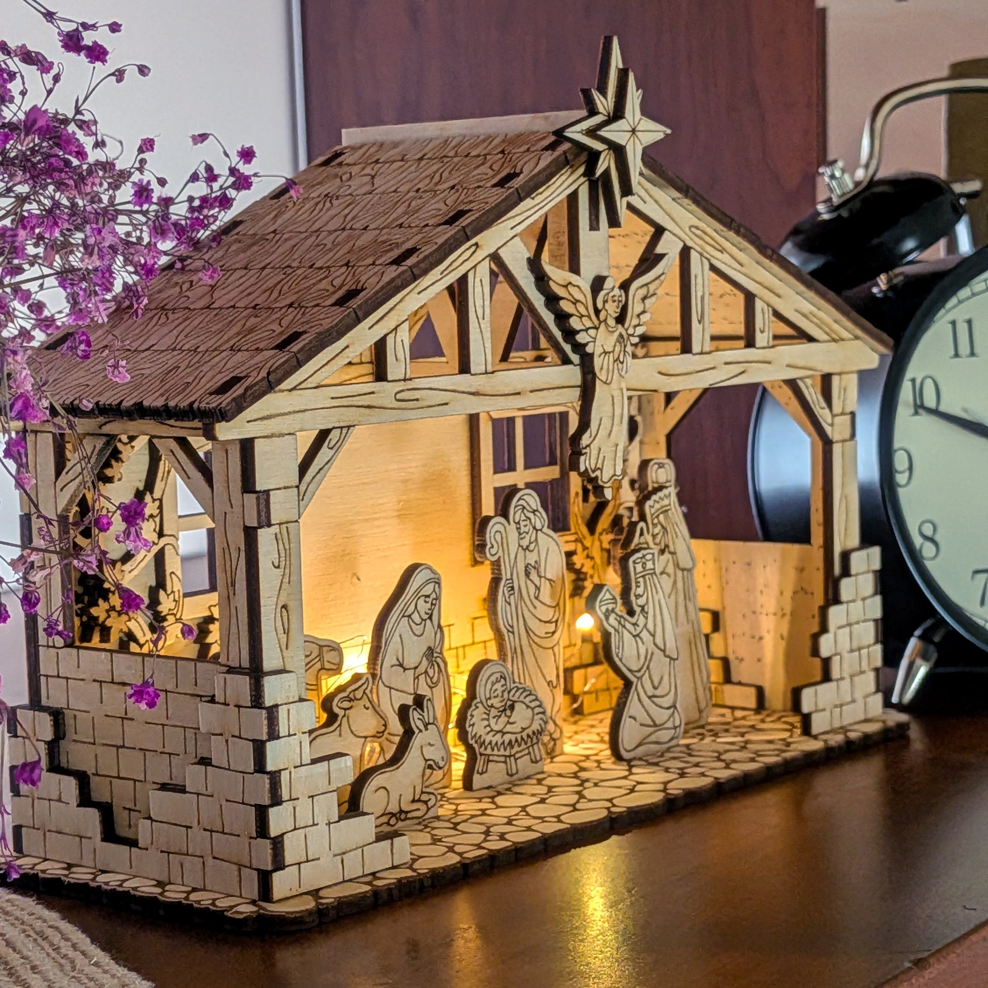 Wooden Nativity Scene laser cut display with Mary, Joseph, Baby Jesus and animals under a Bethlehem stable, warm LED backlight. DIY Christmas decor made from a digital laser cut file template