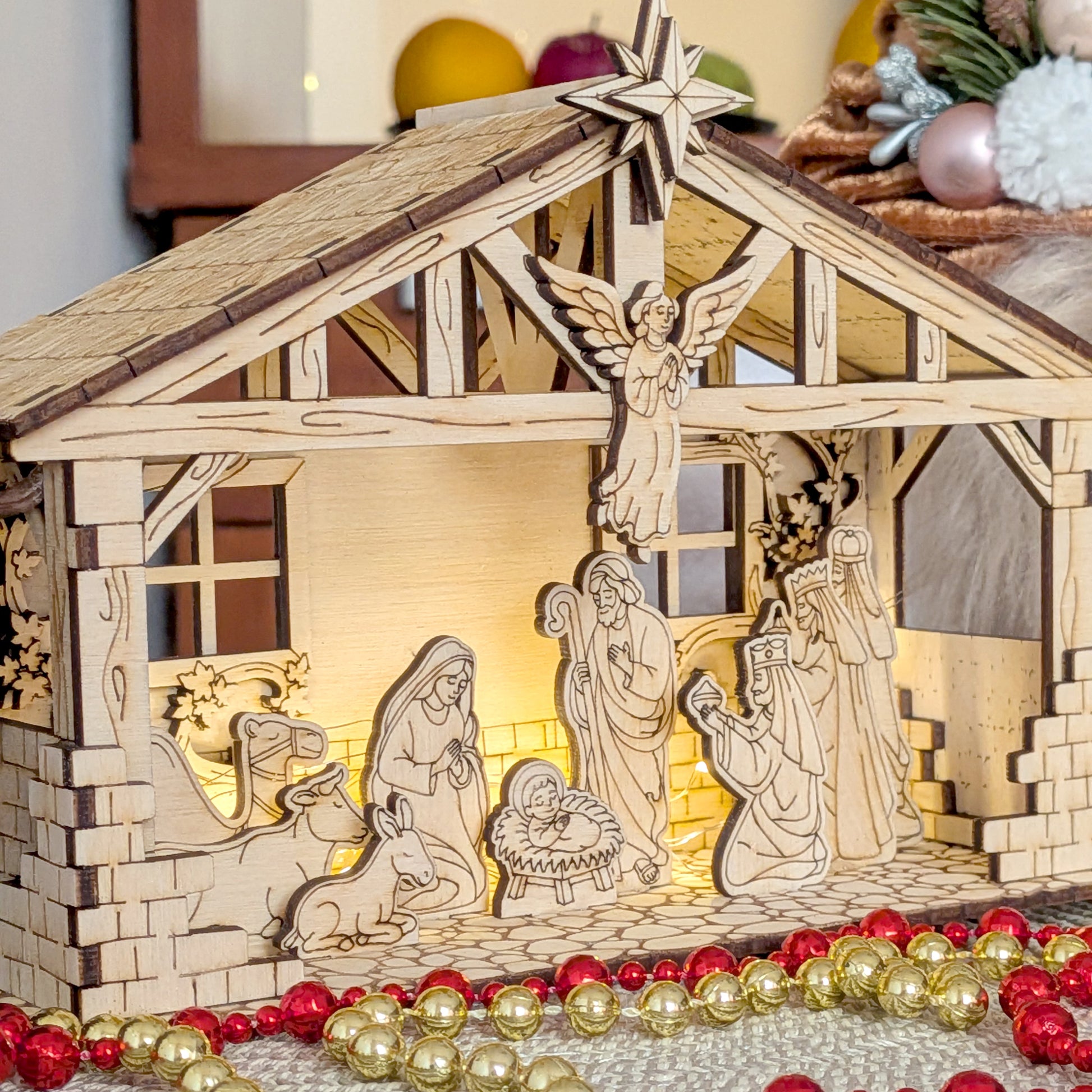 Close-up of a wooden layered Nativity Scene with Mary, Joseph, baby Jesus, animals and the Three Wise Men inside a stable, lit with warm lights. Designed as a laser cut digital template for wood