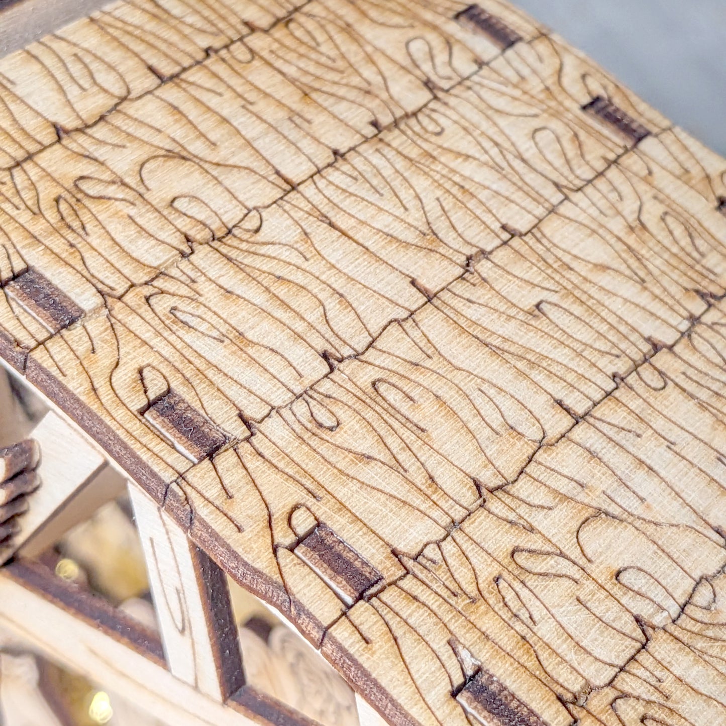 Close-up view of the wooden textured roof on a laser cut Nativity Scene. Detailed engraved wood pattern for DIY Christmas decor project
