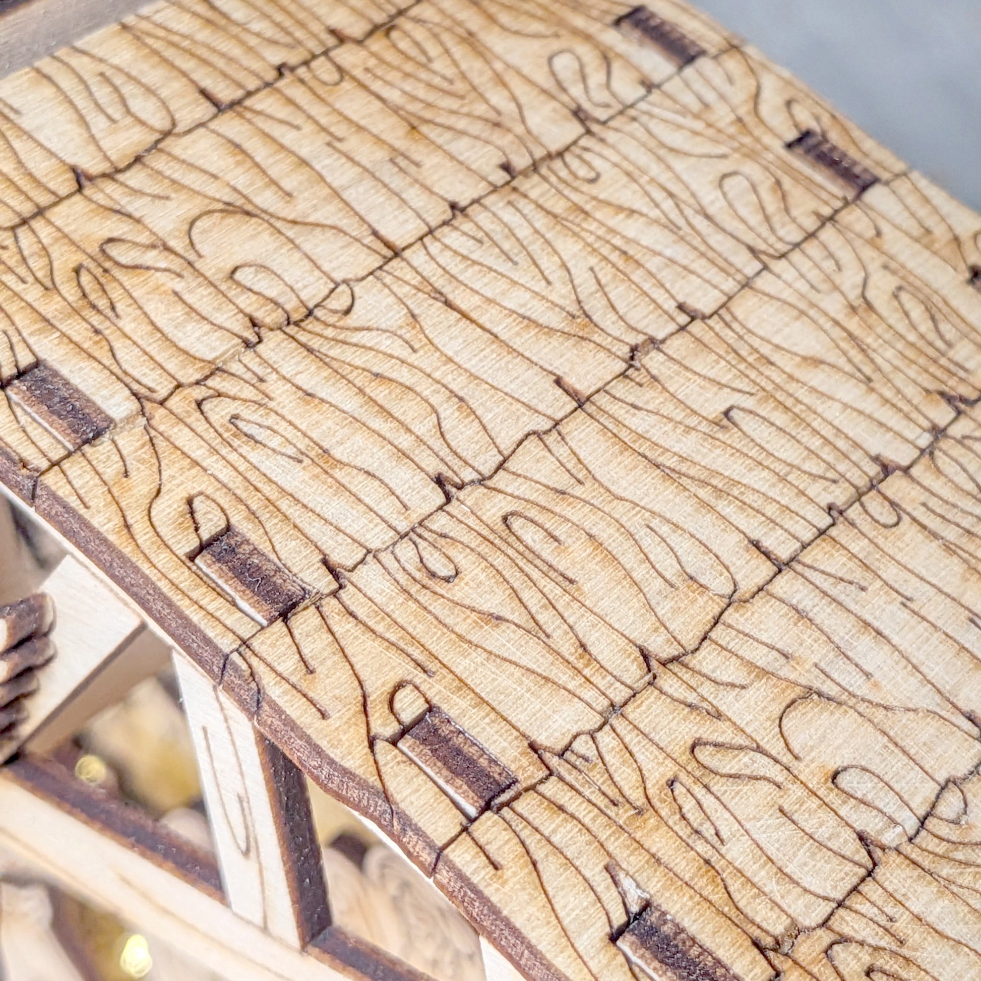 Close-up view of the wooden textured roof on a laser cut Nativity Scene. Detailed engraved wood pattern for DIY Christmas decor project