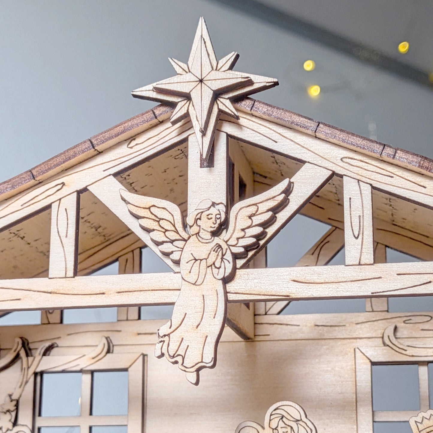 Close-up of wooden Nativity Scene laser cut angel and Bethlehem star detail on the stable roof. Christmas decoration made from a digital laser cut template file