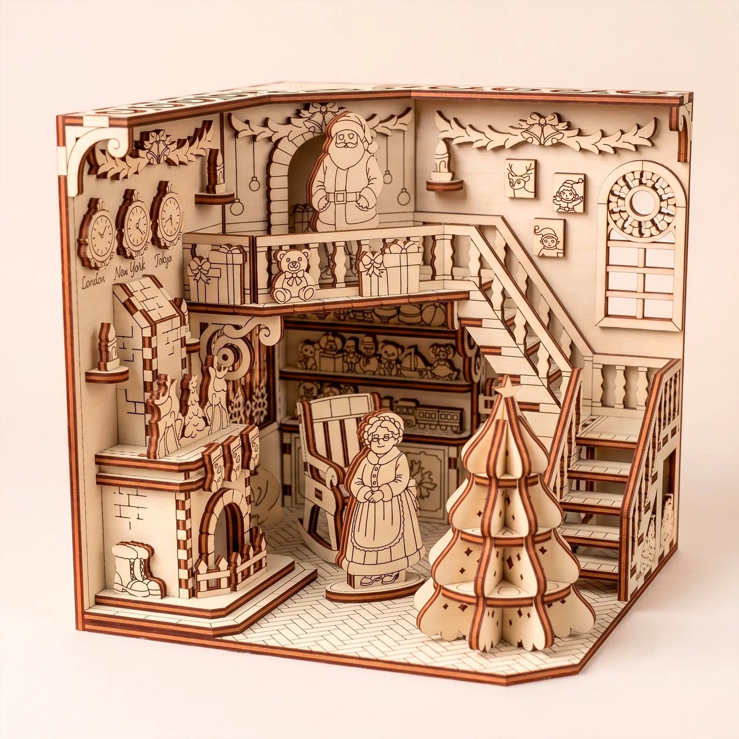 Santa's workshop book nook in laser cut plywood with Christmas tree, fireplace, and staircase. White background.