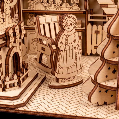 Detail of a laser cut plywood Mrs. Claus figurine standing on a herringbone floor near a rocking chair.