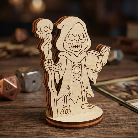 A close-up of a handcrafted laser-cut wooden necromancer miniature. The figurine features intricate skeletal details, a skull staff, and an open book. Shown in a professional gaming setup with blurred polyhedral dice and RPG cards in the background.