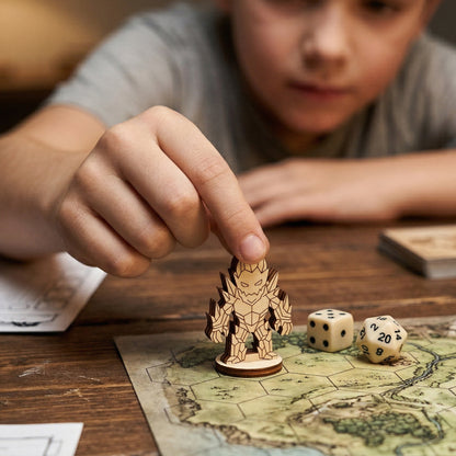 A hand places a laser cut plywood crystal golem on a hex map next to dice, demonstrating its scale for tabletop gaming.