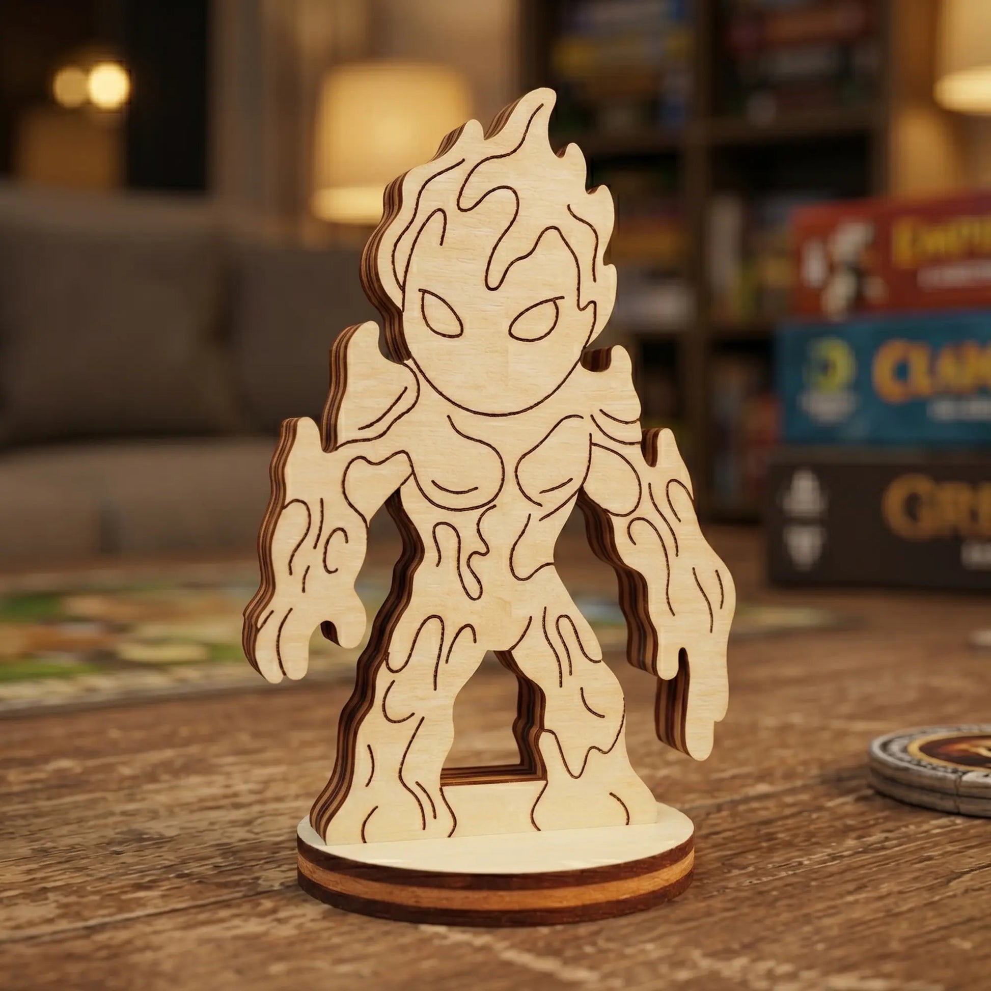 Close-up of a laser cut plywood lava elemental figurine with engraved drip patterns. Standing on a wooden table with game boxes.