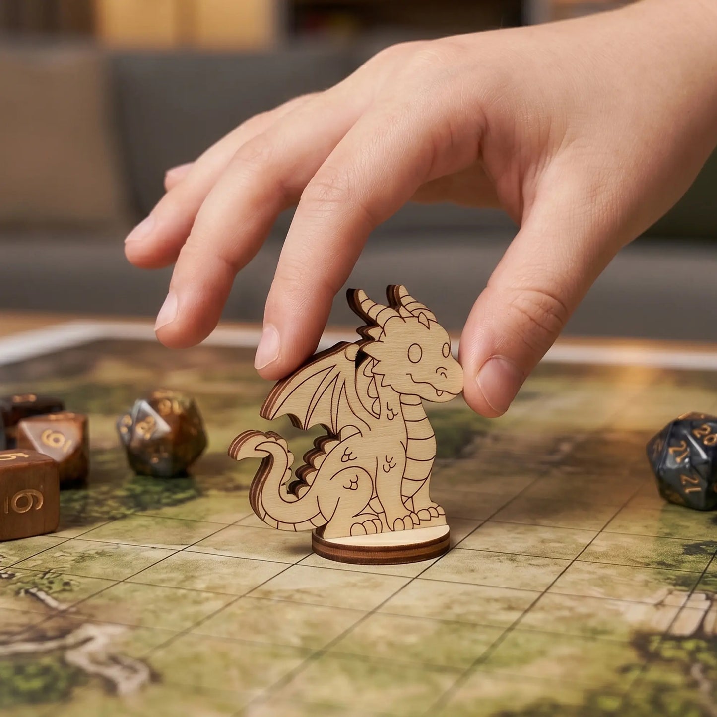 Hand placing a laser cut plywood dragon figurine on a square grid map, showcasing its use as a versatile tabletop RPG miniature.