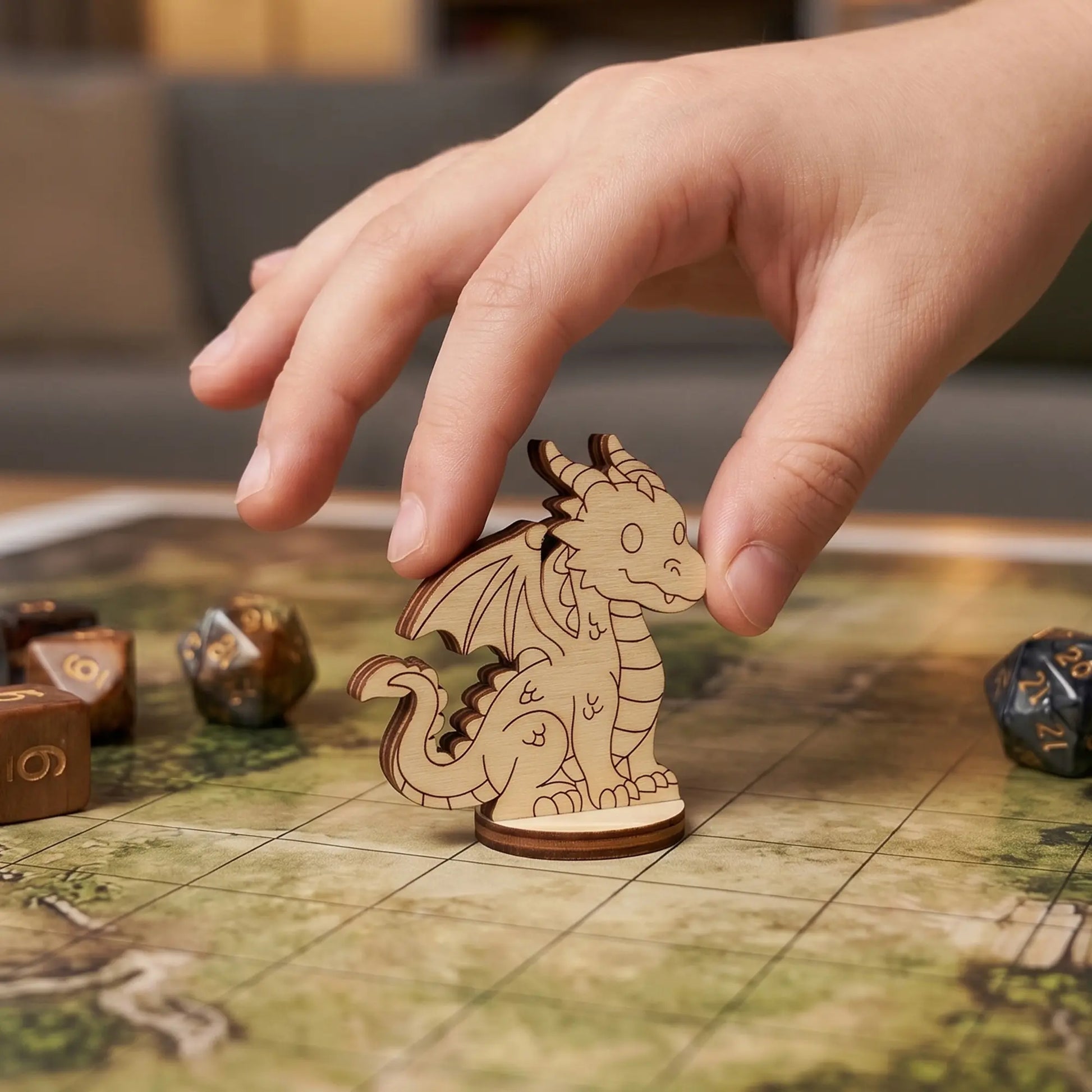 Hand placing a laser cut plywood dragon figurine on a square grid map, showcasing its use as a versatile tabletop RPG miniature.