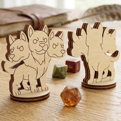 Front and back view of a three-headed Cerberus dog figurine in laser cut plywood with engraved details, next to the wooden RPG dice.