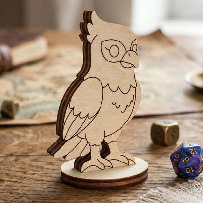 Side view of a laser cut plywood falcon bird figurine with engraved feathers, standing on a map near a shiny purple galaxy die.