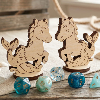 Front and back views of laser cut plywood mythical seahorse figurines on linen with blue and teal polyhedral gaming dice