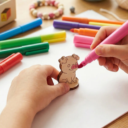 A child coloring an engraved miniature farm pig figurine of laser cut plywood with a pink felt tip marker pen.