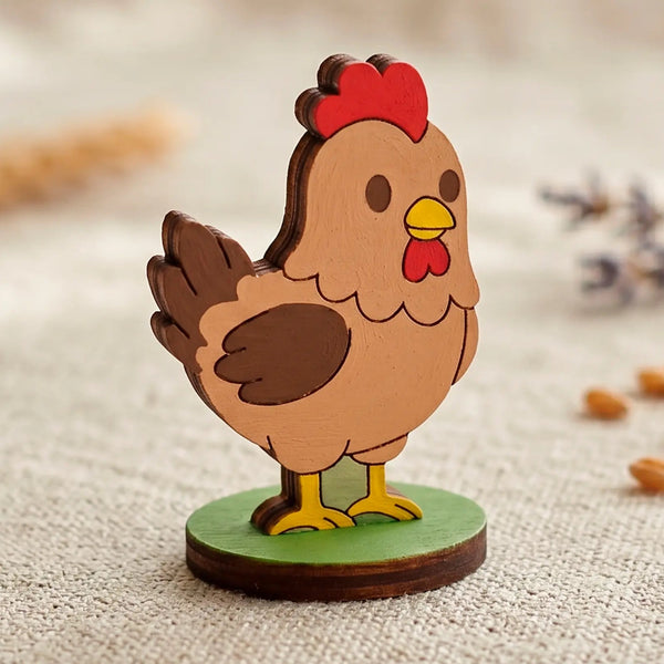 Painted laser cut plywood cute checken miniature on a green base standing on a textured textile surface with wheat grain