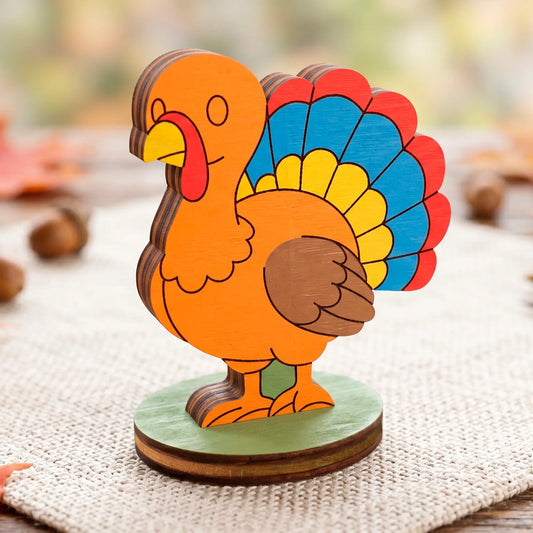 Colorful painted laser cut plywood turkey toy with bright blue, red, and yellow feathers on a green round stand.