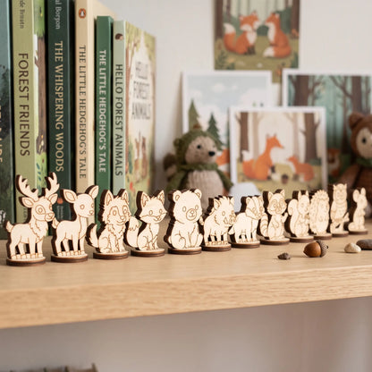 Lineup of 12 laser cut plywood forest animal standing figurines displayed on a nursery bookshelf near storybooks.
