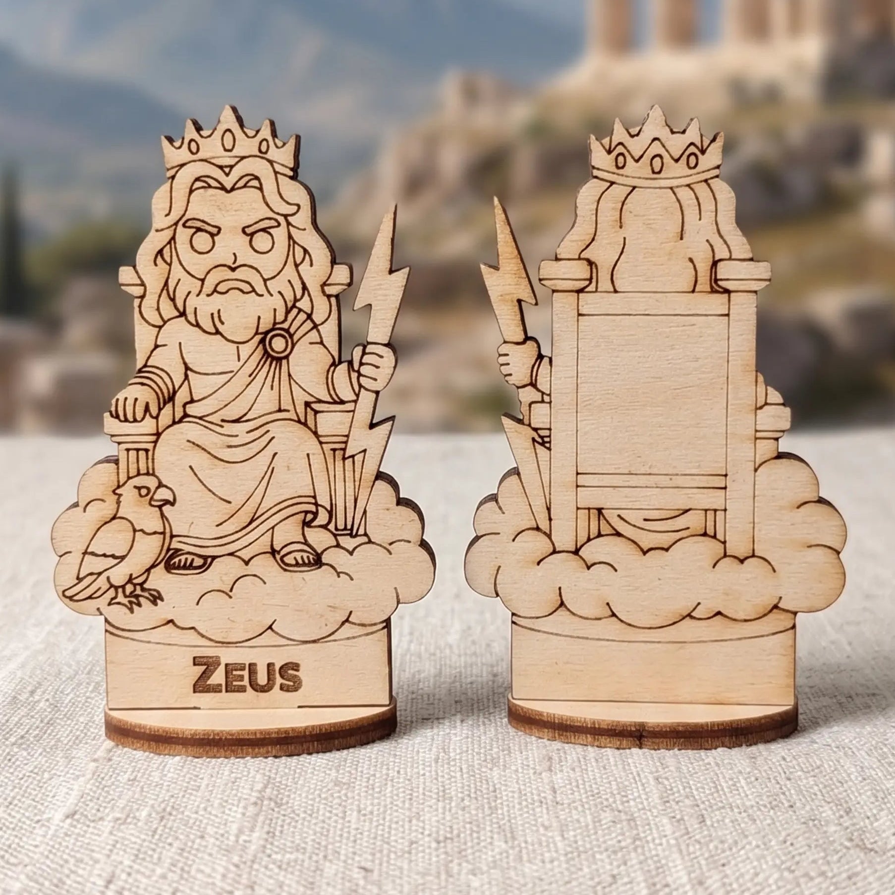 Laser cut plywood Zeus miniature showing front and back views on cloud throne with lightning bolt against Greek ruins