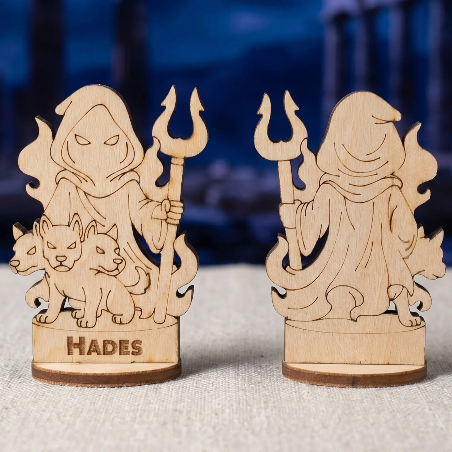 Front and back views of a laser cut plywood Hades figurine with three-headed Cerberus against blurred ancient night ruins