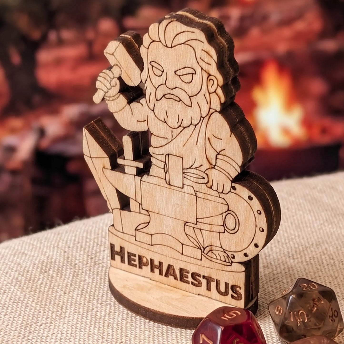 Macro shot of laser cut plywood Hephaestus miniature on fabric with amber polyhedral RPG dice for tabletop gaming scale