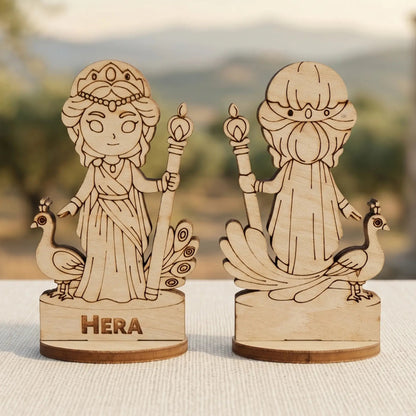 Laser cut plywood Hera miniature front and back views with peacocks and staff, standing against blurred ancient Greek ruins.