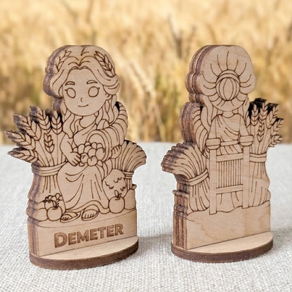 Angled view of a laser cut plywood Demeter figurine showing the layered wood edges and detailed back engraving of wheat bundles