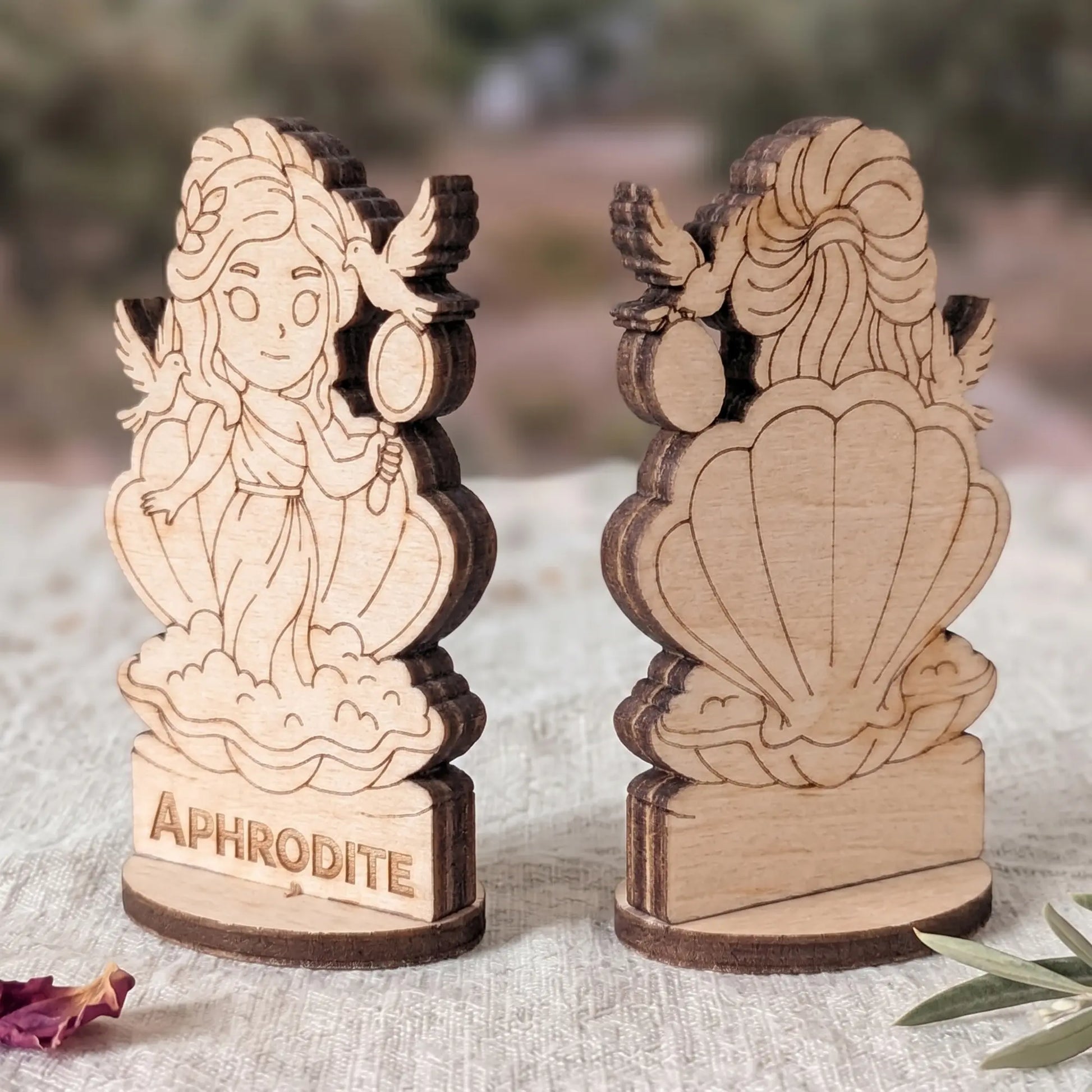 Angled side view of a laser cut plywood Aphrodite figurine showing dark burnt wood edges and detailed layered texture
