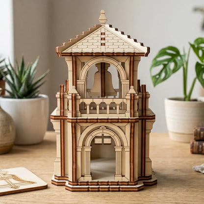 Straight front view of a miniature wooden bell tower craft model made of laser cut plywood on a bright office desk.