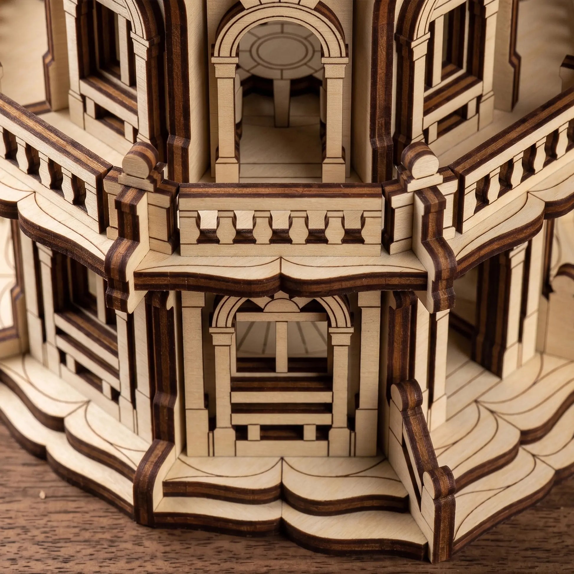 Macro close-up of tiered miniature balconies and archways on a palace craft model made from layered laser cut plywood.
