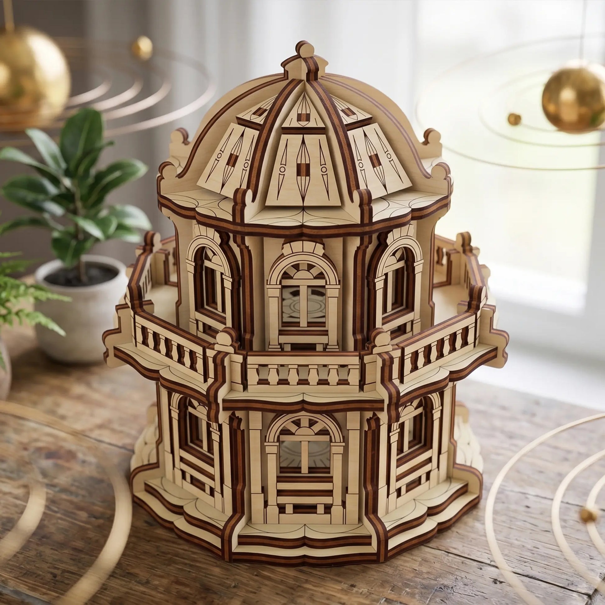 Miniature laser cut plywood observatory dome model staged on a rustic table near indoor plants and gold ornaments.