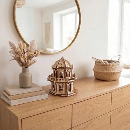 Miniature dome temple made of laser cut plywood displayed on a modern wooden dresser beneath a round wall mirror.