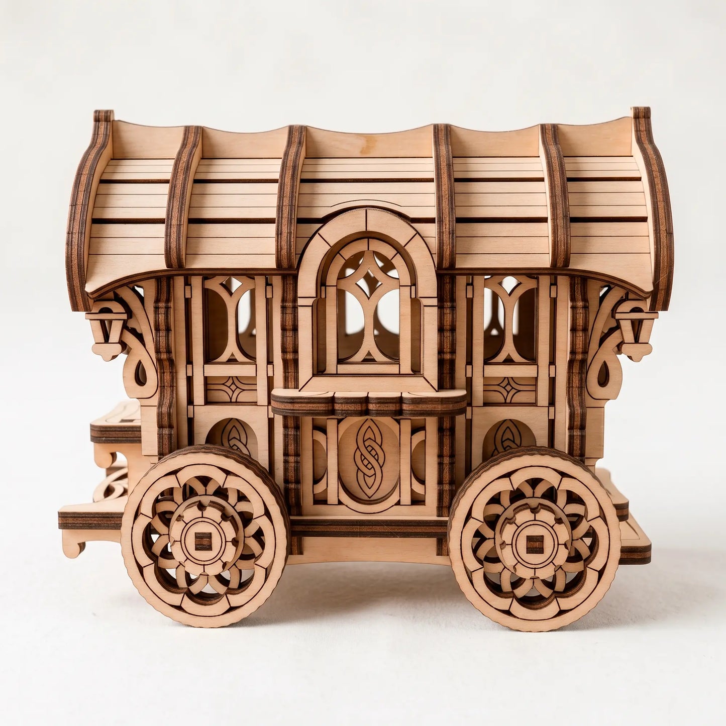 Laser-cut plywood vintage caravan model kit, side profile showing intricate window patterns and detailed wheels.