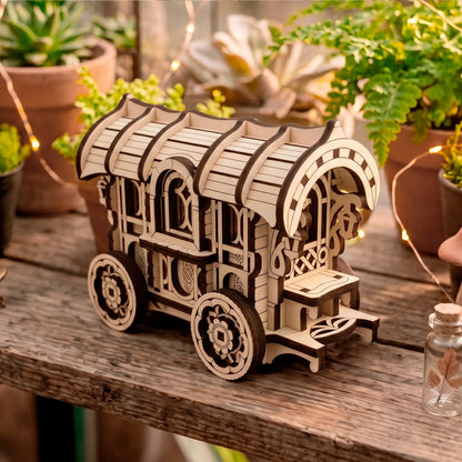 Three-quarter view of the laser-cut wooden wagon model resting on a rustic wooden bench, with potted succulents and fairy lights.
