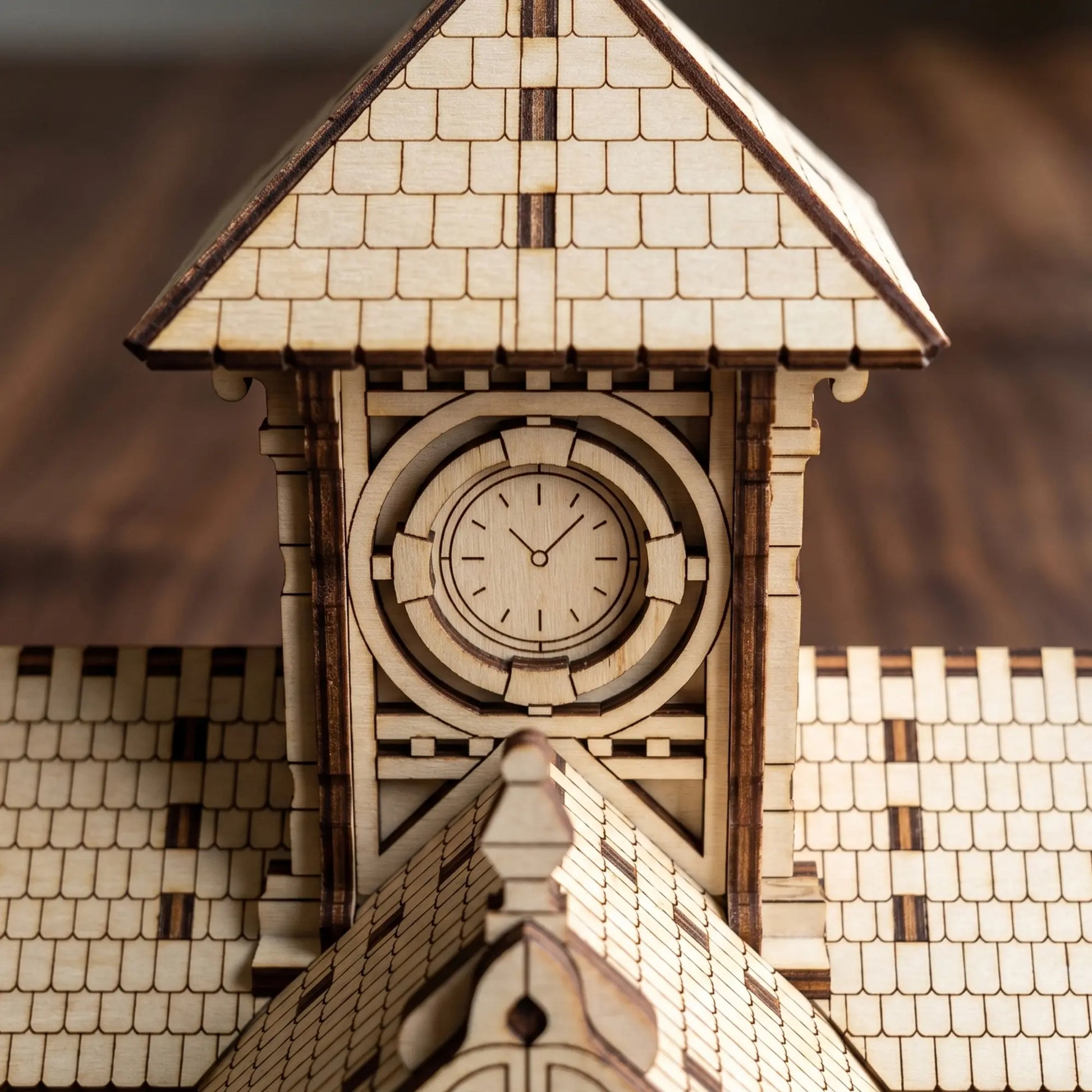 Macro close-up showing the engraved dial hands and face on a miniature clock tower made from laser cut plywood.