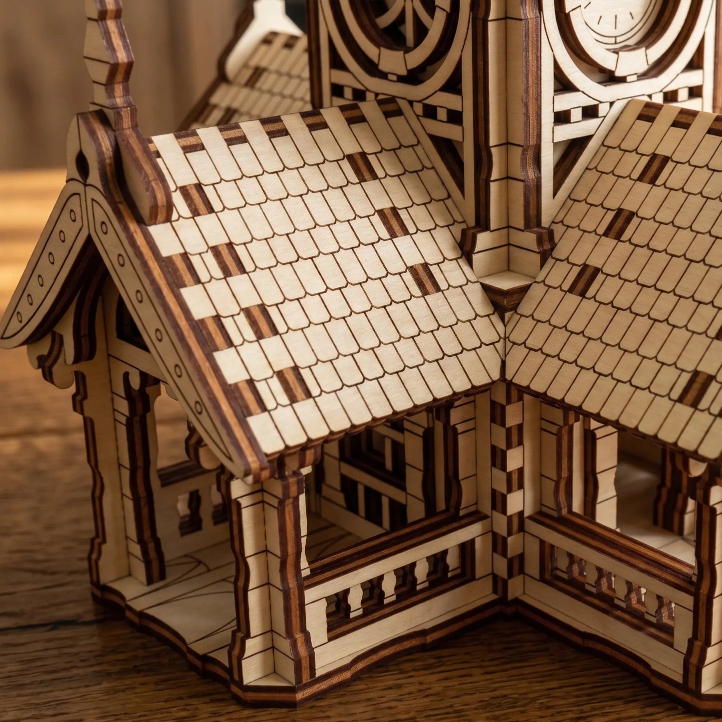 Extreme close-up of the textured shingle roof and small veranda on a laser cut plywood clock tower house toy.
