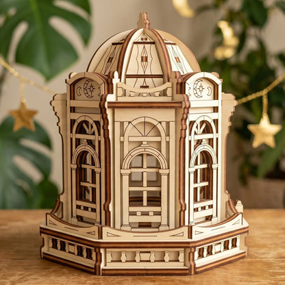 Eye-level view of a miniature wooden rotunda building with gothic window frames made from laser cut plywood sheets.