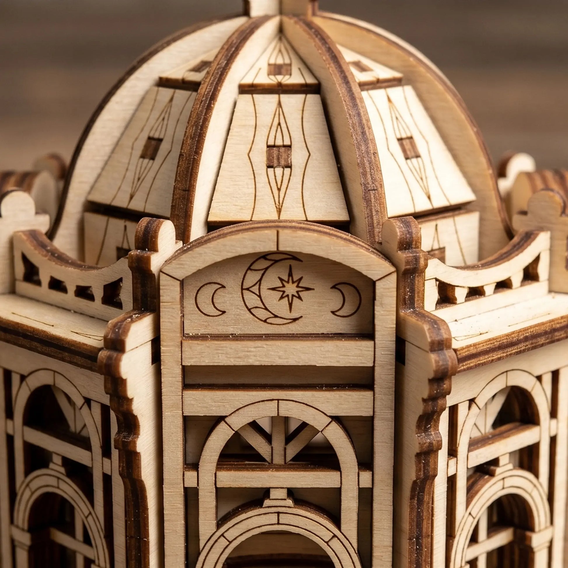 Close-up of the engraved crescent moon and star emblem on an architectural miniature of laser cut plywood.