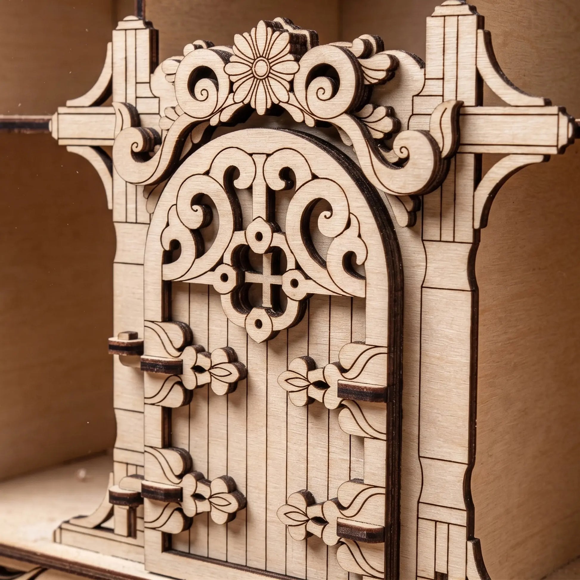 Detailed view of the intricate miniature front door with decorative swirls on a laser cut plywood bug hotel house.