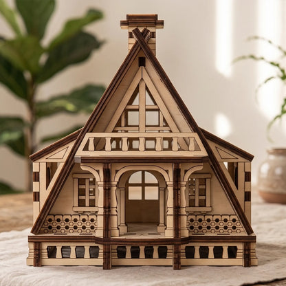 Front view of a miniature wooden fairy house with a steep roof, assembled from layered laser cut plywood panels.