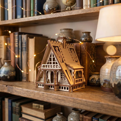 Miniature wooden fairy house of laser cut plywood displayed on a rustic bookshelf among vintage books and vases.