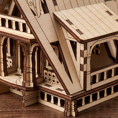 Close-up view showing the veranda pillars and delicate window frames of a laser cut plywood fairy house model.