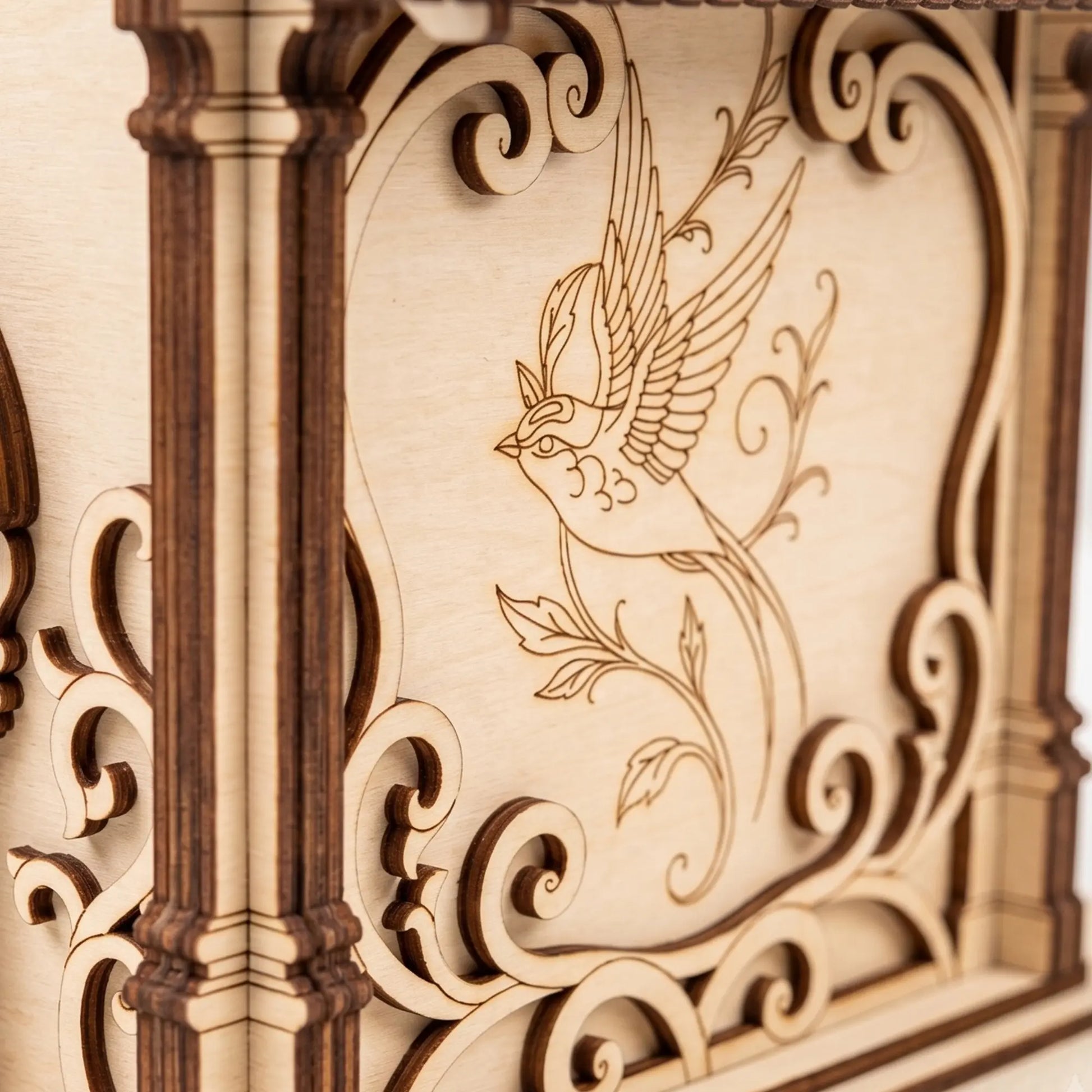 Extreme close-up of an intricate bird engraving on the side panel of a laser cut plywood birdhouse model.