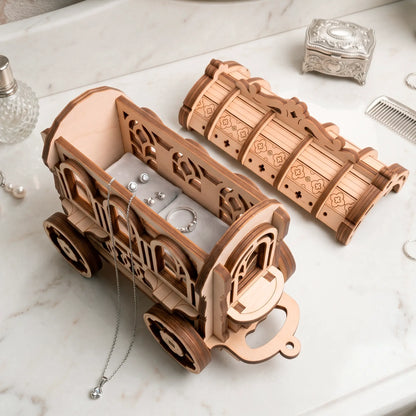 An open laser-cut plywood fairy cart serving as a jewelry organizer with a velvet lining, sparkling earrings, and a ring.