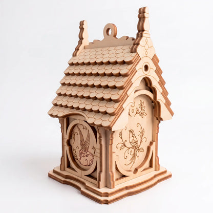 An unpainted wooden laser-cut plywood birdhouse displaying detailed engraved bird and leaf patterns on multiple outer walls.