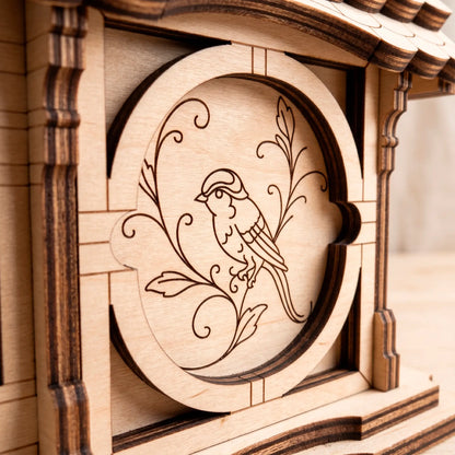 Detailed macro close-up of a laser-cut plywood side panel featuring a precisely engraved bird sitting on a floral branch.